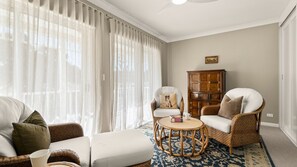 A living room with a sofa, armchairs, a round table, and a cabinet. - The Leafy Outlook Family Stay in Randwick (Randwick)