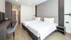 Una habitación de hotel moderna con dos camas, un escritorio y una silla.