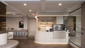 A modern kitchen with a curved island, built-in appliances, and a glass partition. - Surestay Plus by Best Western Ramkhamhaeng Airport Rail Link Bangkok (Bangkok)