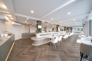 A modern hotel lobby with a long reception desk, seating area, and a herringbone wood floor. - Surestay Plus by Best Western Ramkhamhaeng Airport Rail Link Bangkok (Bangkok)