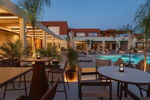 Un área junto a la piscina con mobiliario exterior y una piscina.