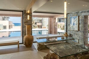 A modern interior with a stone wall, a large vase, and a glass table. - Volta Seaside Hotel - Adult-only (Hersonissos)