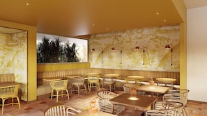 A restaurant interior with a yellow color scheme, wicker furniture, and patterned wallpaper.