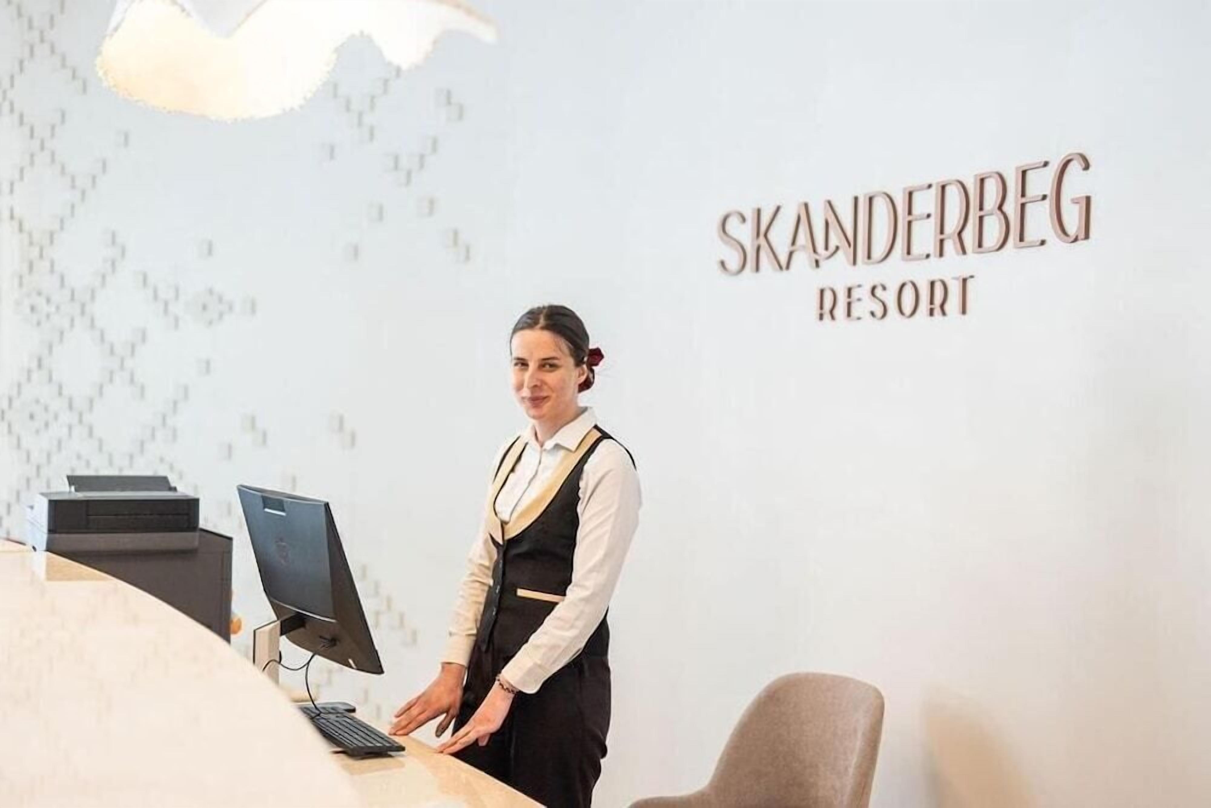 A reception desk at Skanderbeg Resort with a computer and a printer.