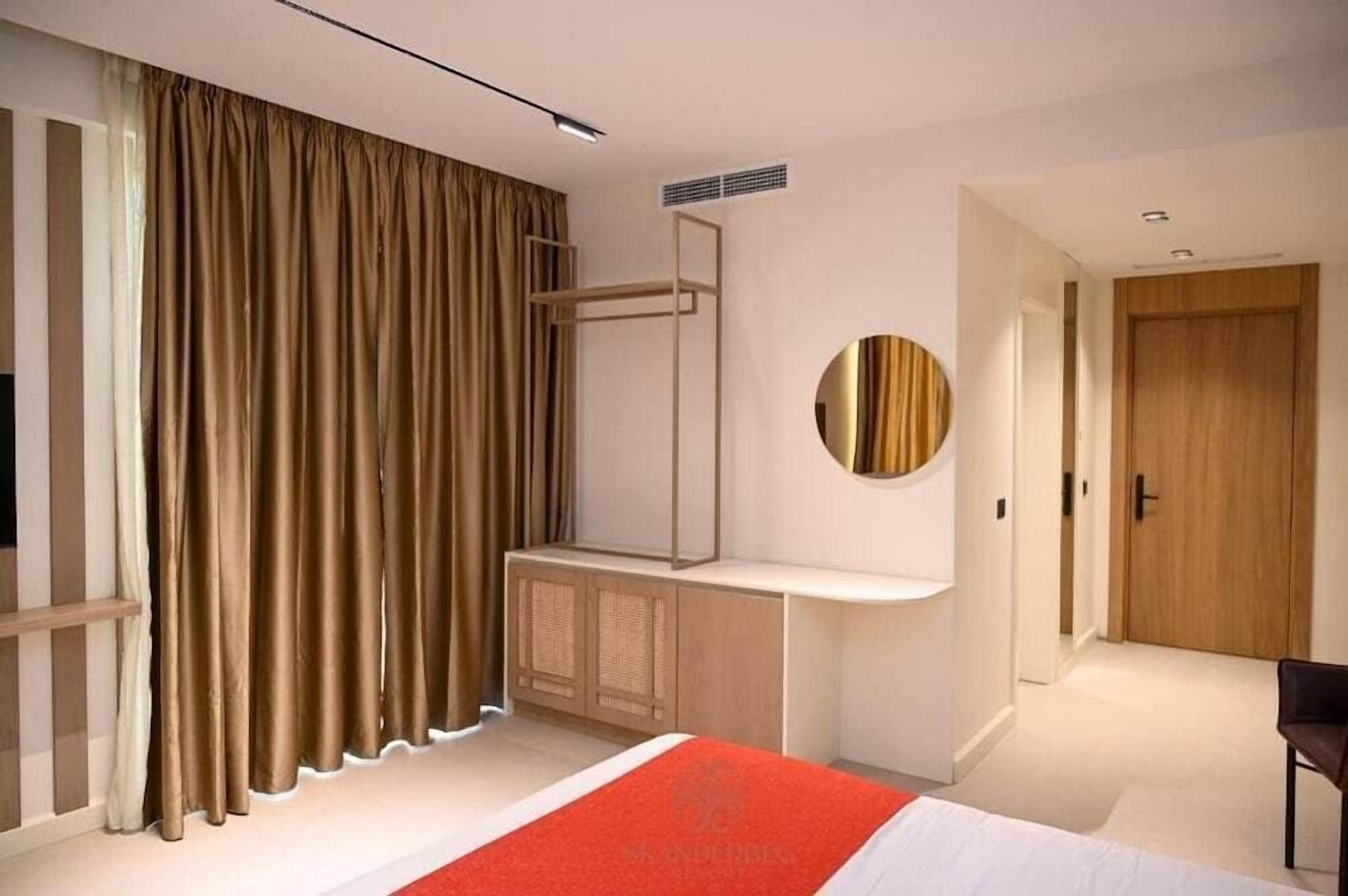 Ein modernes Schlafzimmer mit Bett, Nachttisch, Spiegel und Kleiderschrank.