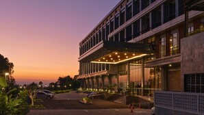 A modern hotel with a two-story structure, large windows, and a covered entrance area. - Laska Hotel and Resort Ciater (Ciater)