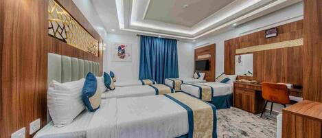 A hotel room with a large bed, a desk, and a chair.