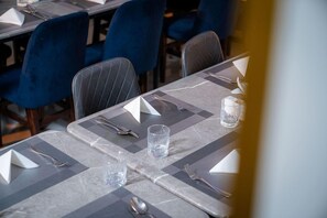 A table set for dining with a checkered tablecloth, silverware, and a glass of water. - Almarzam Hotel (Madinah)