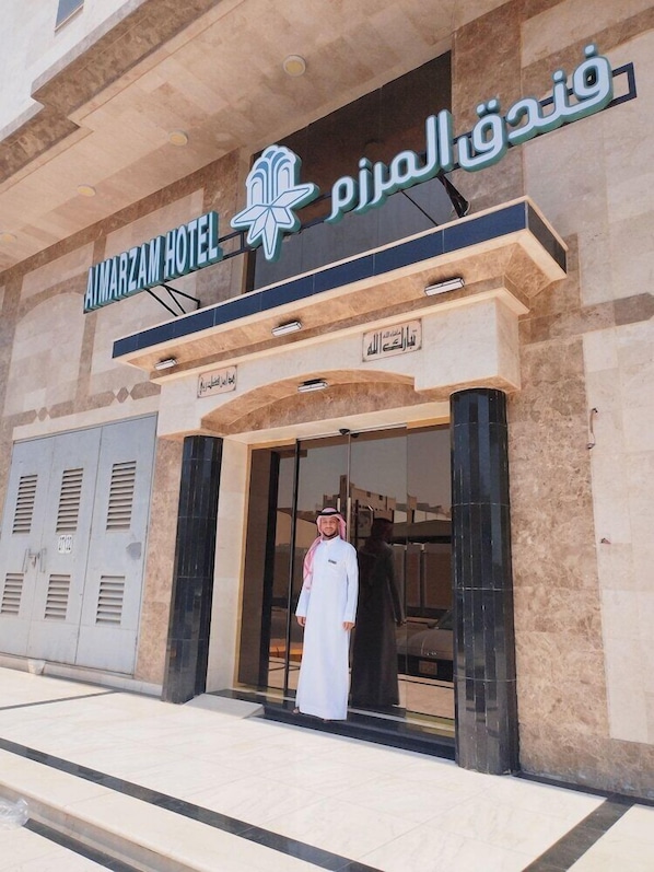 The exterior of the Almarazam Hotel with a clear entrance and a sign in Arabic. - Almarzam Hotel (Madinah)