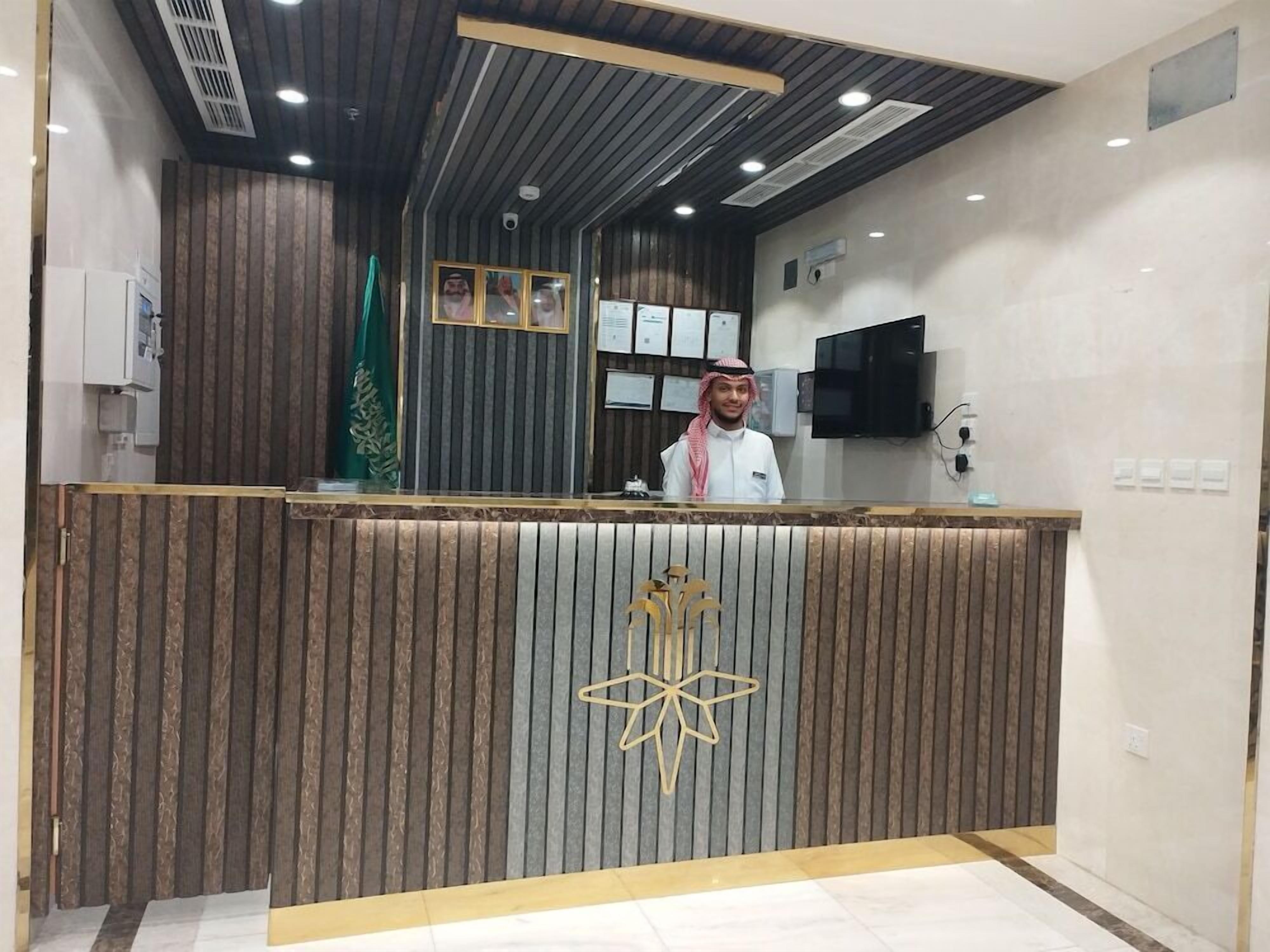 A reception desk with a modern design, featuring a wooden panel backdrop and a star-shaped logo.