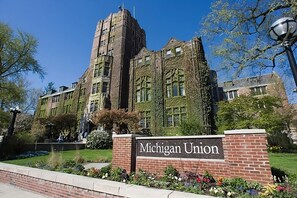 Ein historisches Gebäude mit efeuüberwucherten Mauern und einem markanten Turm, mit der Aufschrift "Michigan Union".