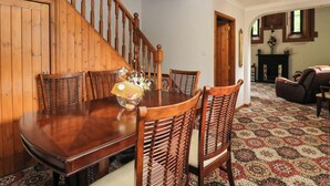 A dining area with a wooden staircase, a dining table, and chairs. - Ardlui Church (Arrochar)