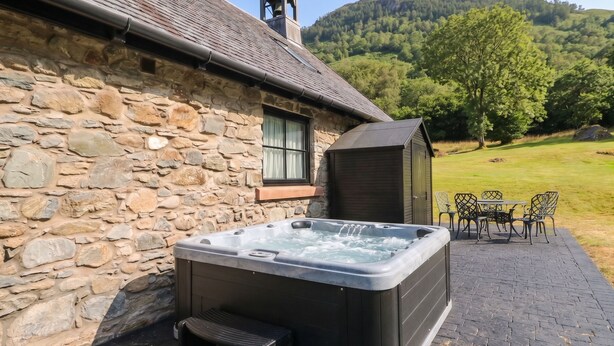 A stone building with a hot tub and outdoor seating. - Ardlui Church (Arrochar)