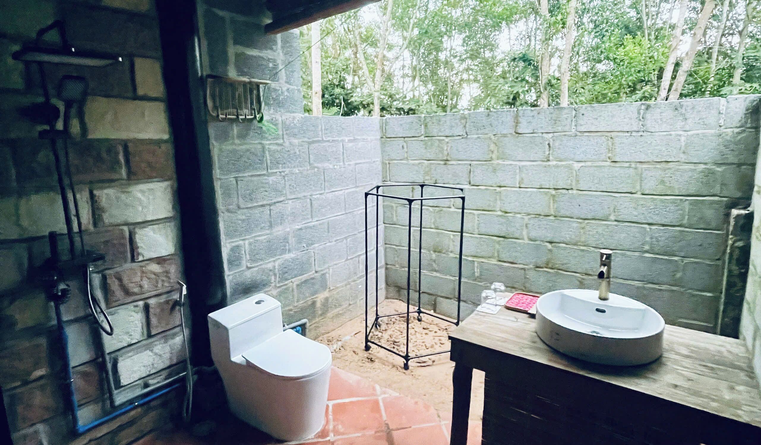 Casa de banho com chuveiro, sanita e lavatório.