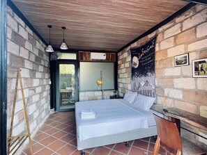 A bedroom with a bed, a wooden ladder, a window, and a wall with a poster.