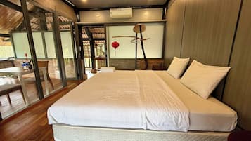 Une chambre à coucher avec un grand lit, une porte vitrée donnant sur un espace extérieur et une lanterne rouge accrochée au mur.