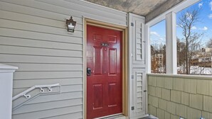 A red door with a mailbox and a small window above it. - Mountain Haven | Cozy Stowe Escape (Stowe)