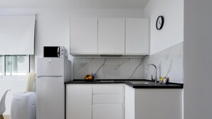 Eine moderne Küche mit weißen Schränken, einem Backofen, einer Mikrowelle und einem Spülbecken mit Armatur.