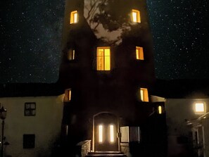 Una torre con numerosas ventanas iluminadas de noche.