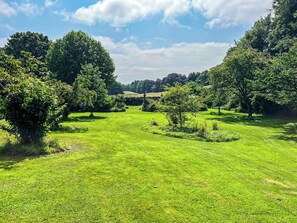 A well-maintained grassy area with trees and a clear sky.