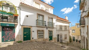 A cobblestone street with buildings featuring balconies and traditional windows. - GuestReady – Romantic Lisbon Nook (Lisbon)