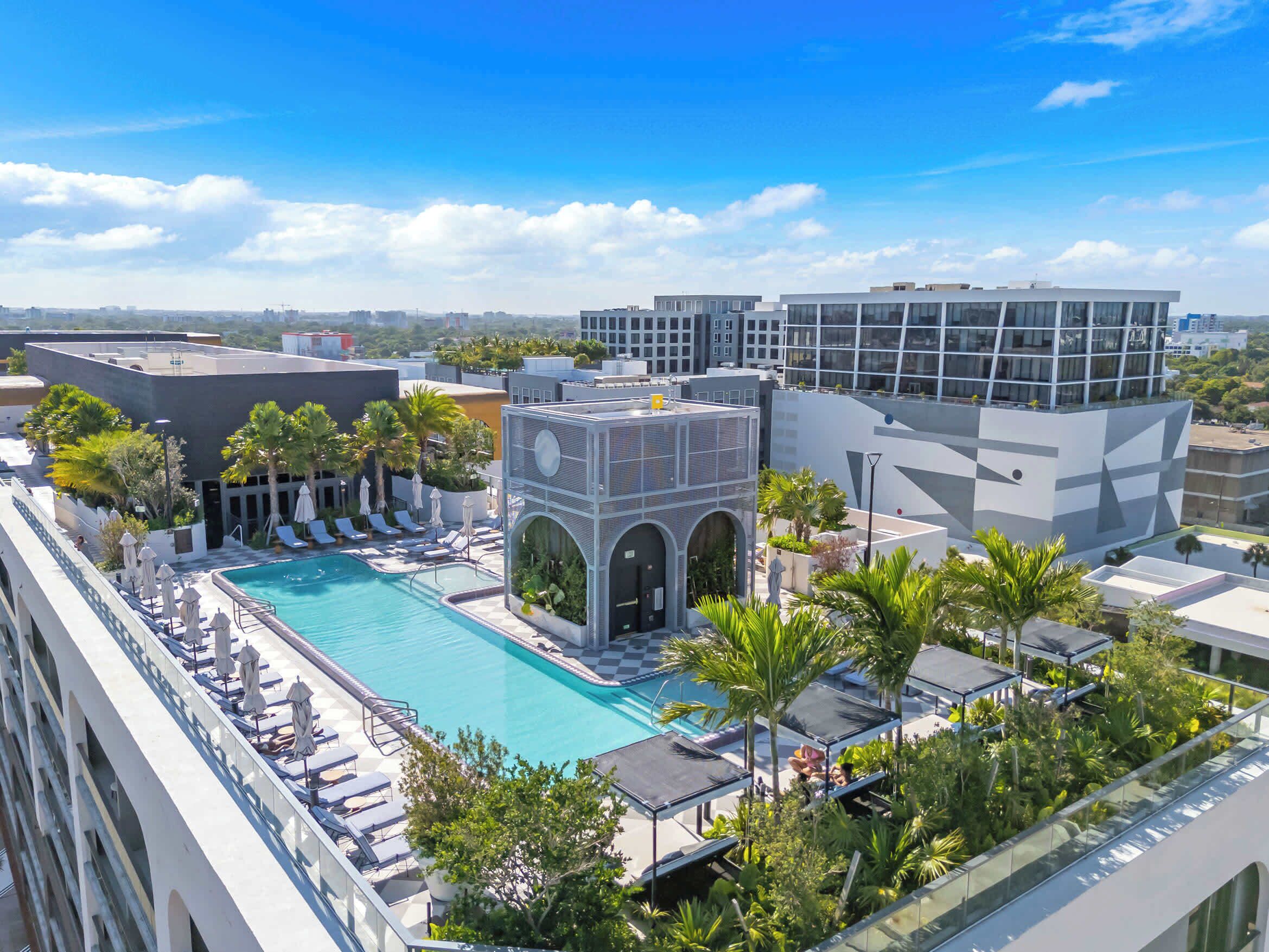 A rooftop pool with lounge chairs and a view of the cityscape.