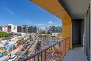 Ein Balkon mit Blick auf eine belebte Straße, Gebäude und Baustellen.