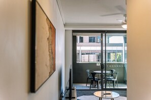 A room with a glass door leading to an outdoor seating area with tables and chairs. - Two Bedroom Sanctuary in the Valley (Fortitude Valley)
