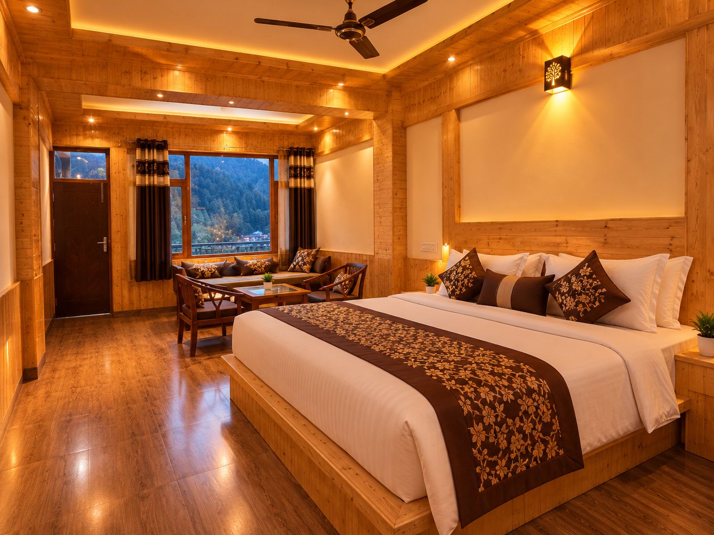 A hotel room with a large bed, a seating area with chairs, a ceiling fan, and a view of the outdoors.