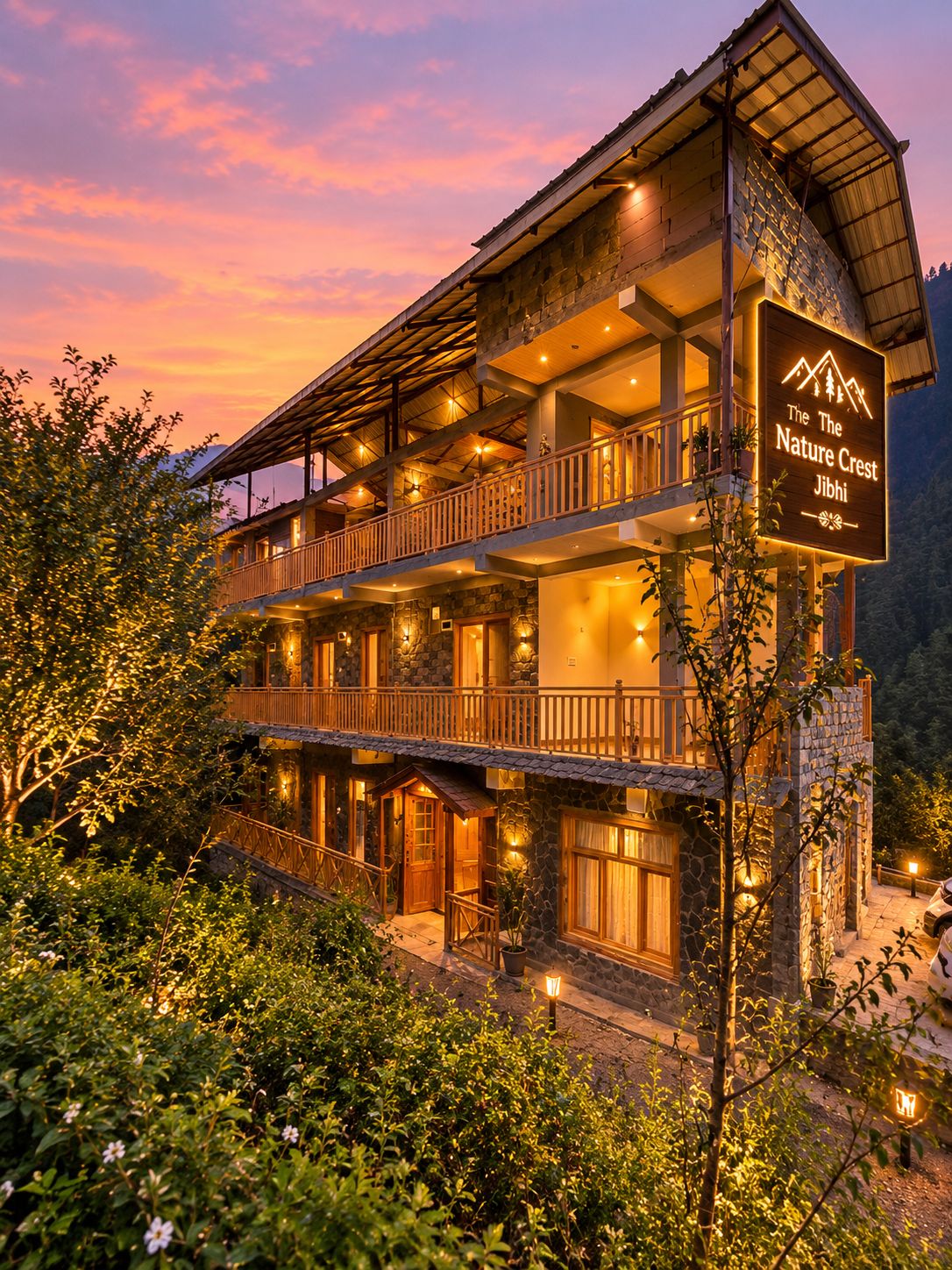 A multi-story hotel with a sign indicating 'The Nature Crest Jibhi.'
