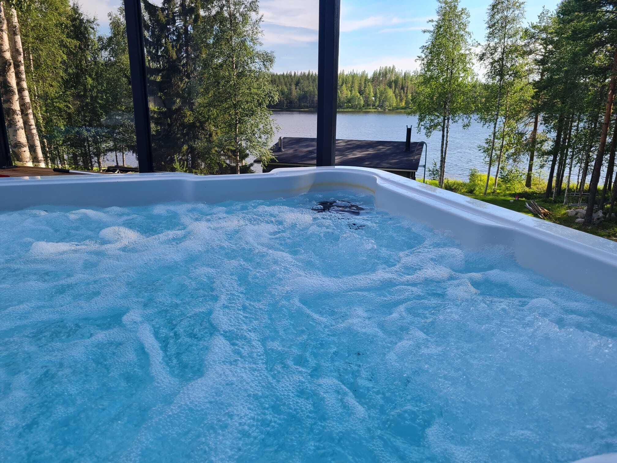 A hot tub with a view of a lake and forest.