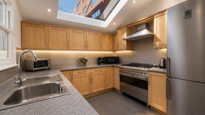 Eine moderne Küche mit Oberlicht, Edelstahlgeräten und Holzschränken.