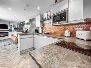A modern kitchen with a built-in microwave, toaster, and coffee maker. - 1 bedroom accommodation in Stranraer (Stranraer)