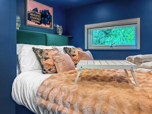 A bedroom with a bed, pillows, a window with a view, and a wall with a poster. - 1 bedroom accommodation in Stranraer (Stranraer)