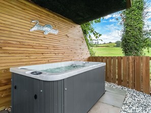 A hot tub with a wooden wall and a sign above it. - 1 bedroom accommodation in Stranraer (Stranraer)