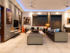 A modern living room with a sofa set, a coffee table, and artwork on the walls. - Rosa Paradise - Luxury 4BR Villa in Seminyak (Keroboken Kelod)