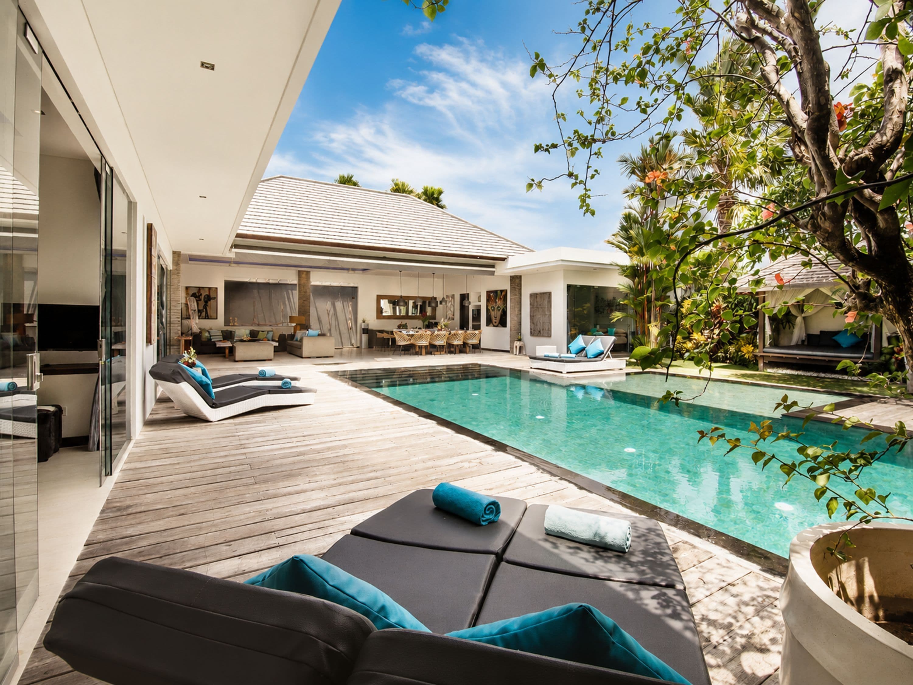 A modern outdoor pool area with lounge chairs and a dining area.