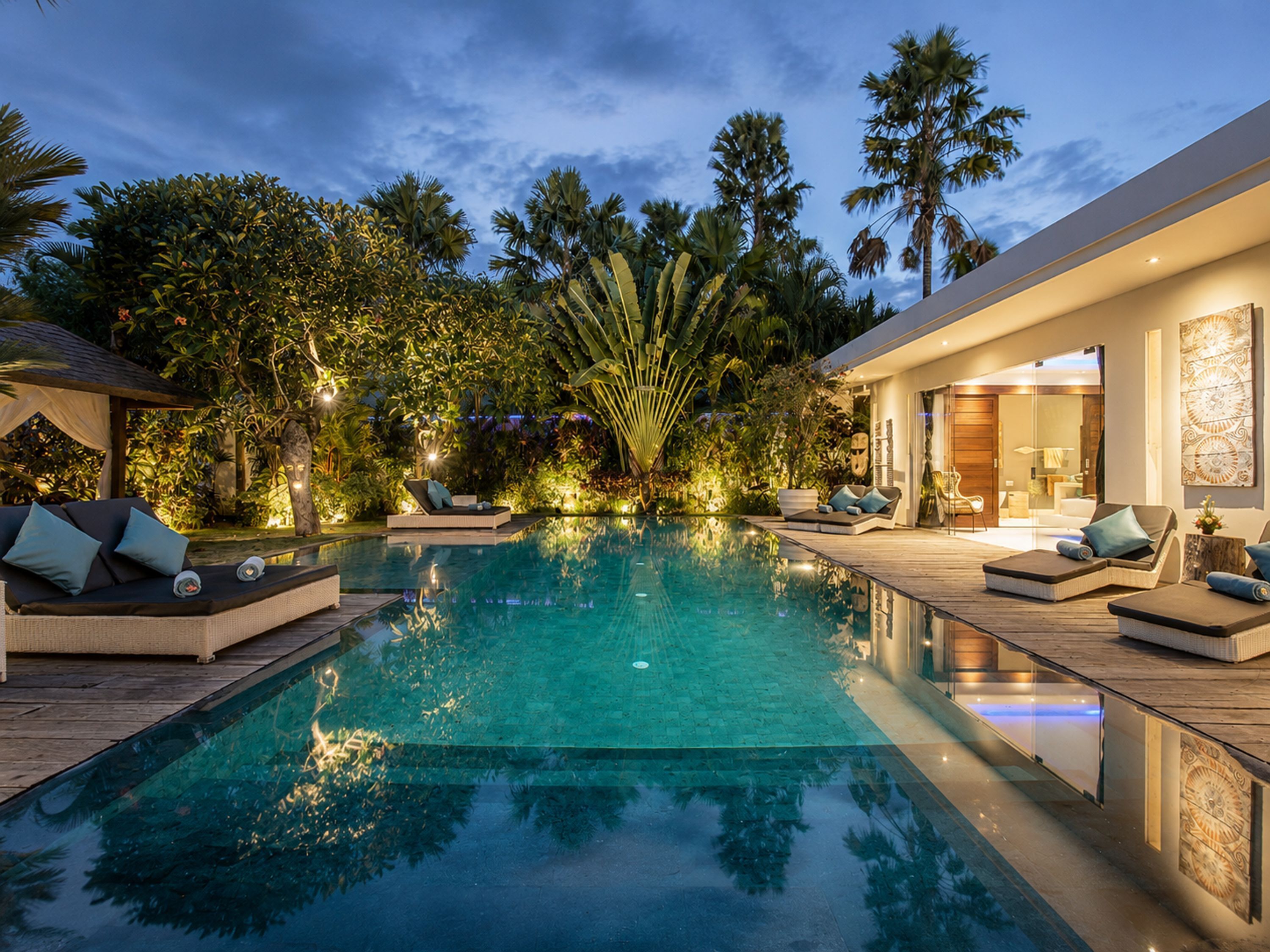 A pool area with lounge chairs and a wooden deck.
