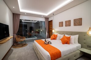 Une chambre d’hôtel moderne dotée d’un grand lit, d’une télévision et d’une porte vitrée donnant sur un balcon.