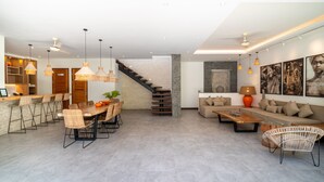 A modern interior with a dining area, kitchen, staircase, and living space. - Modern Coastal 4BR Villa Walk to Finns Canggu (Tibubeneng)