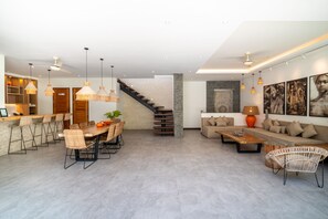 A modern interior with a dining area, kitchen, staircase, and living space. - Modern Coastal 4BR Villa Walk to Finns Canggu (Tibubeneng)