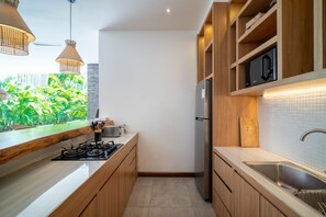 Eine moderne Küche mit Holzschränken, einem Edelstahlkühlschrank und einem Gasherd.