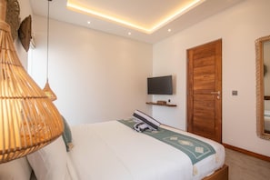 Ein modernes Schlafzimmer mit einem Bett, einem an der Wand befestigten Fernseher und einer Holztür.