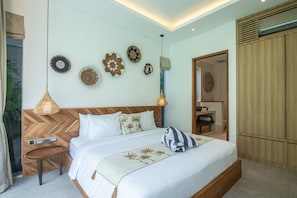 Ein Schlafzimmer mit einem großen Bett, Nachttischen, einem Holzkopfstück, Wanddekoration und einem Kleiderschrank.