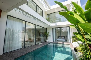 A modern house with a glass-enclosed pool, a dining area, and a bedroom. - Casa Rio-beautiful 3br Villa Center Seminyak (Keroboken Kelod)