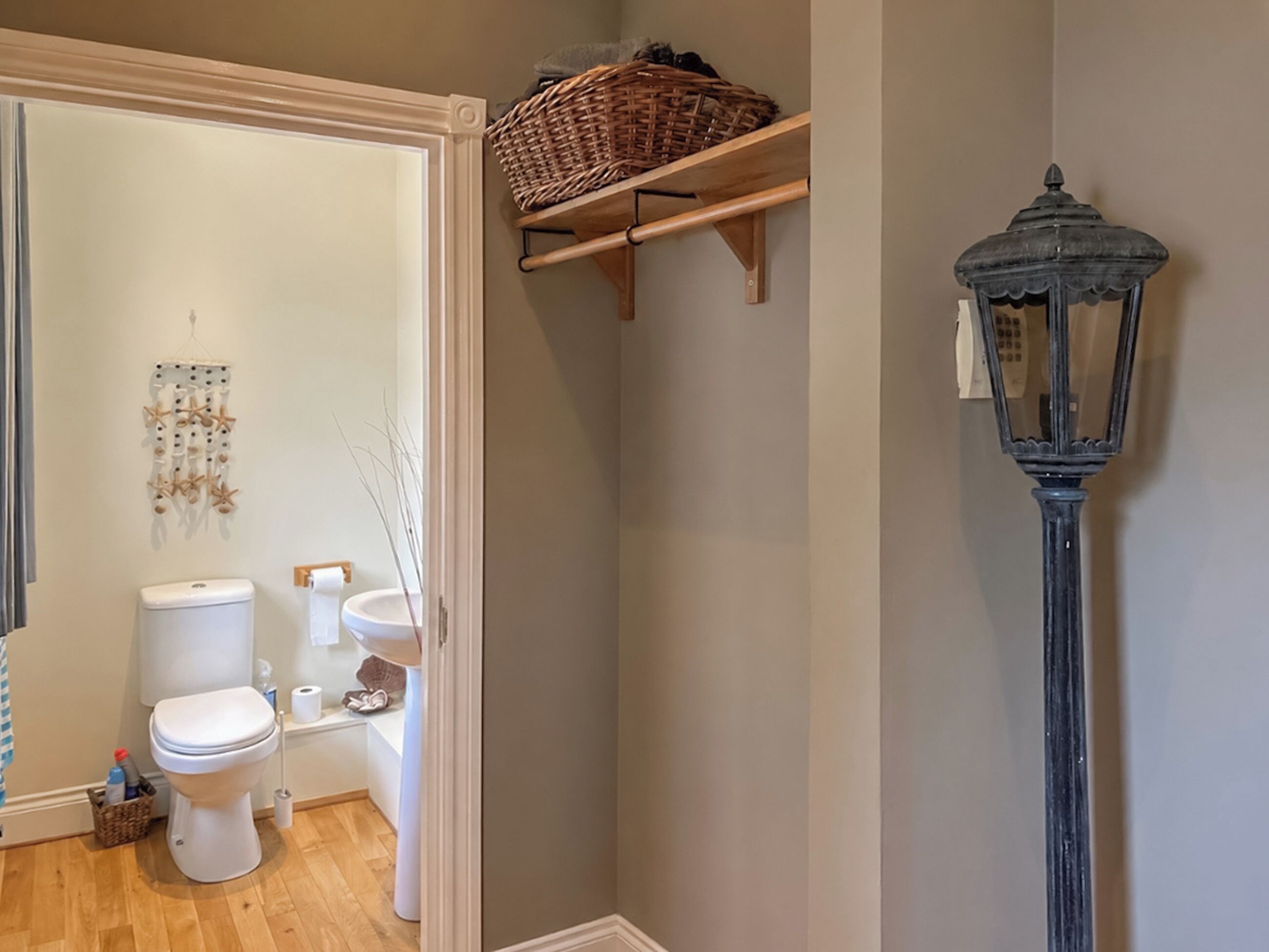 A bathroom with a toilet, bidet, and a decorative wall hanging.