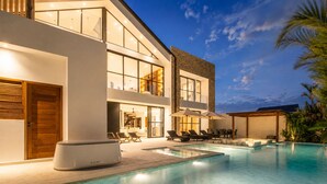 A modern house with a swimming pool, outdoor seating, and a staircase leading to the upper floor. - Modern 4 BR Villa Ocean View Nusa Dua (Nusa Dua)