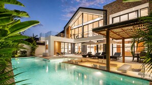 A modern two-story house with a swimming pool, outdoor seating, and a stone facade. - Modern 4 BR Villa Ocean View Nusa Dua (Nusa Dua)