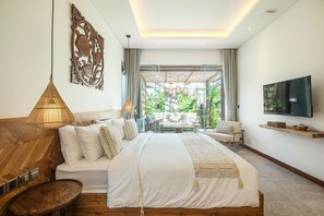 Ein modernes Schlafzimmer mit einem großen Bett, einem Fernseher und Blick ins Freie.
