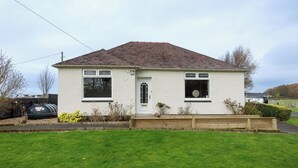 A single-story house with a gabled roof, a front door, and two windows. - The Paddock - UK52288 (Auchincruive)